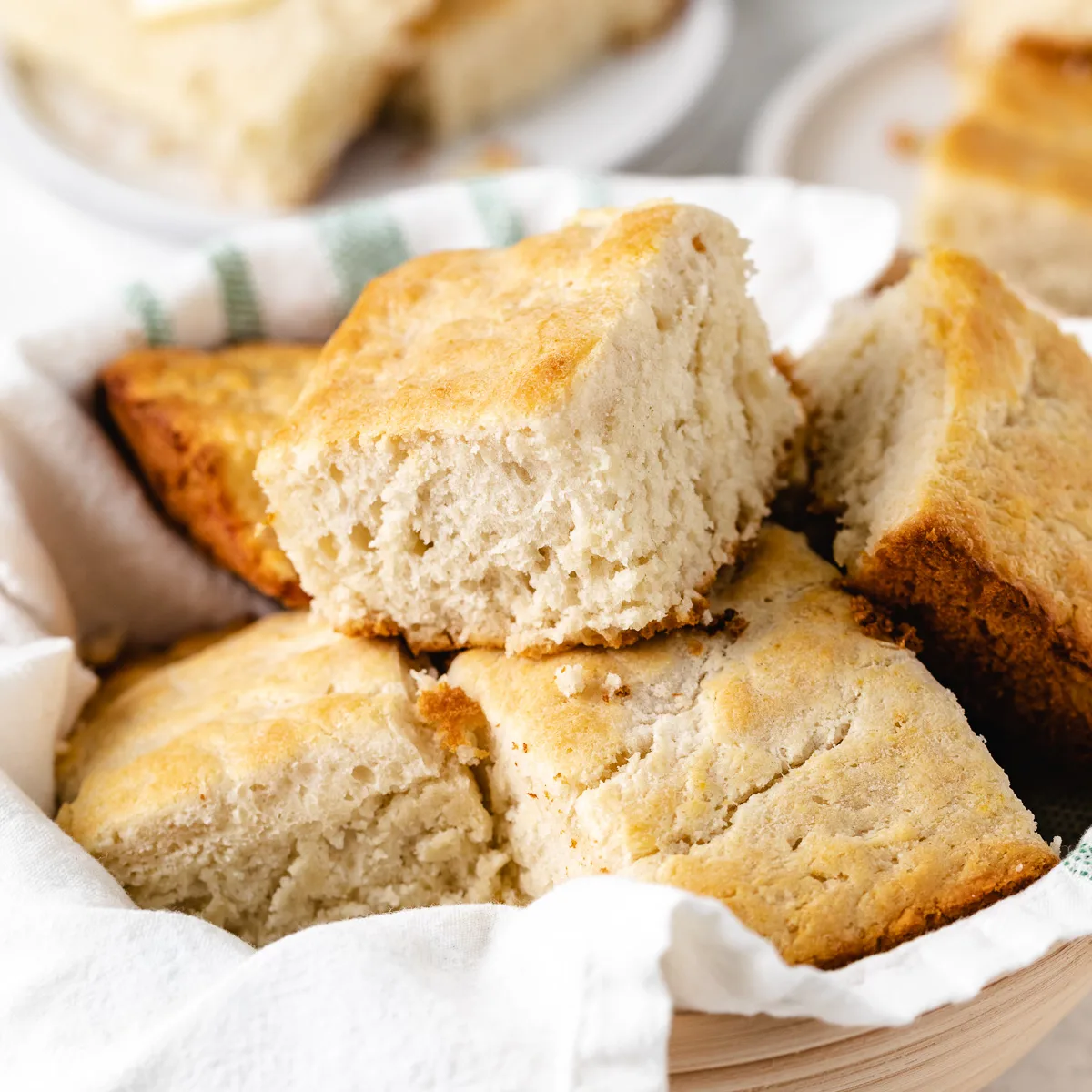 Close up view of a batch of biscuits on a white linen.