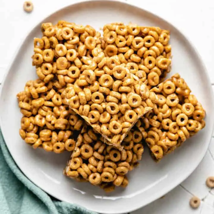 Close up view of a plate of peanut butter cheerio bars.