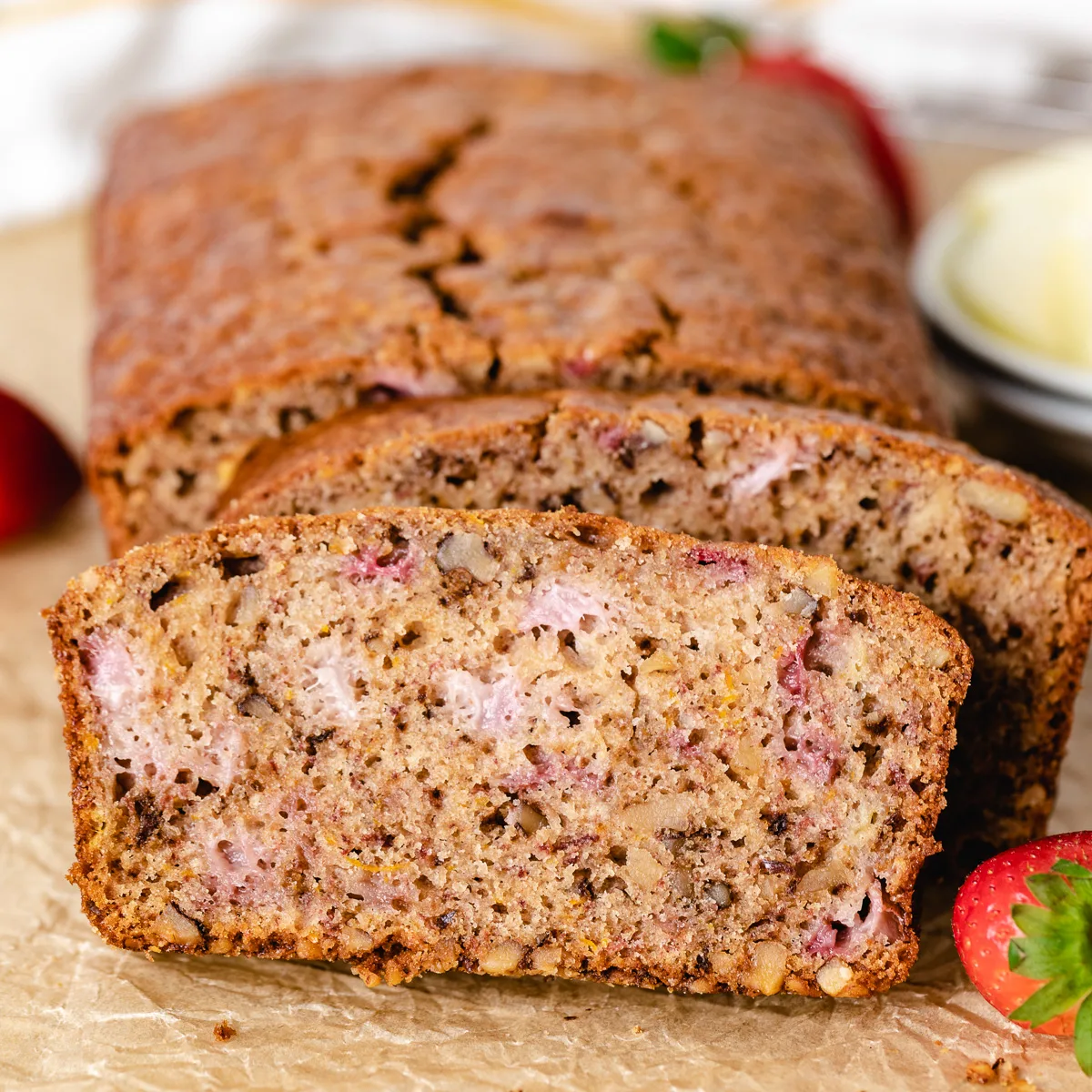 Close up view of a loaf of strawberry bread with nuts.