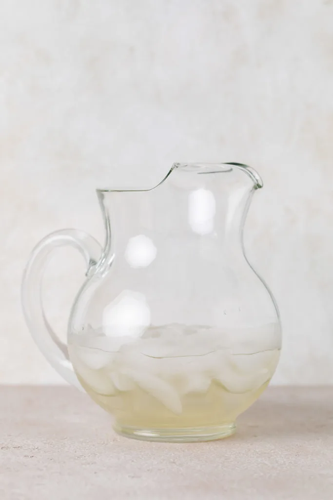 Simple syrup poured into a pitcher over ice.