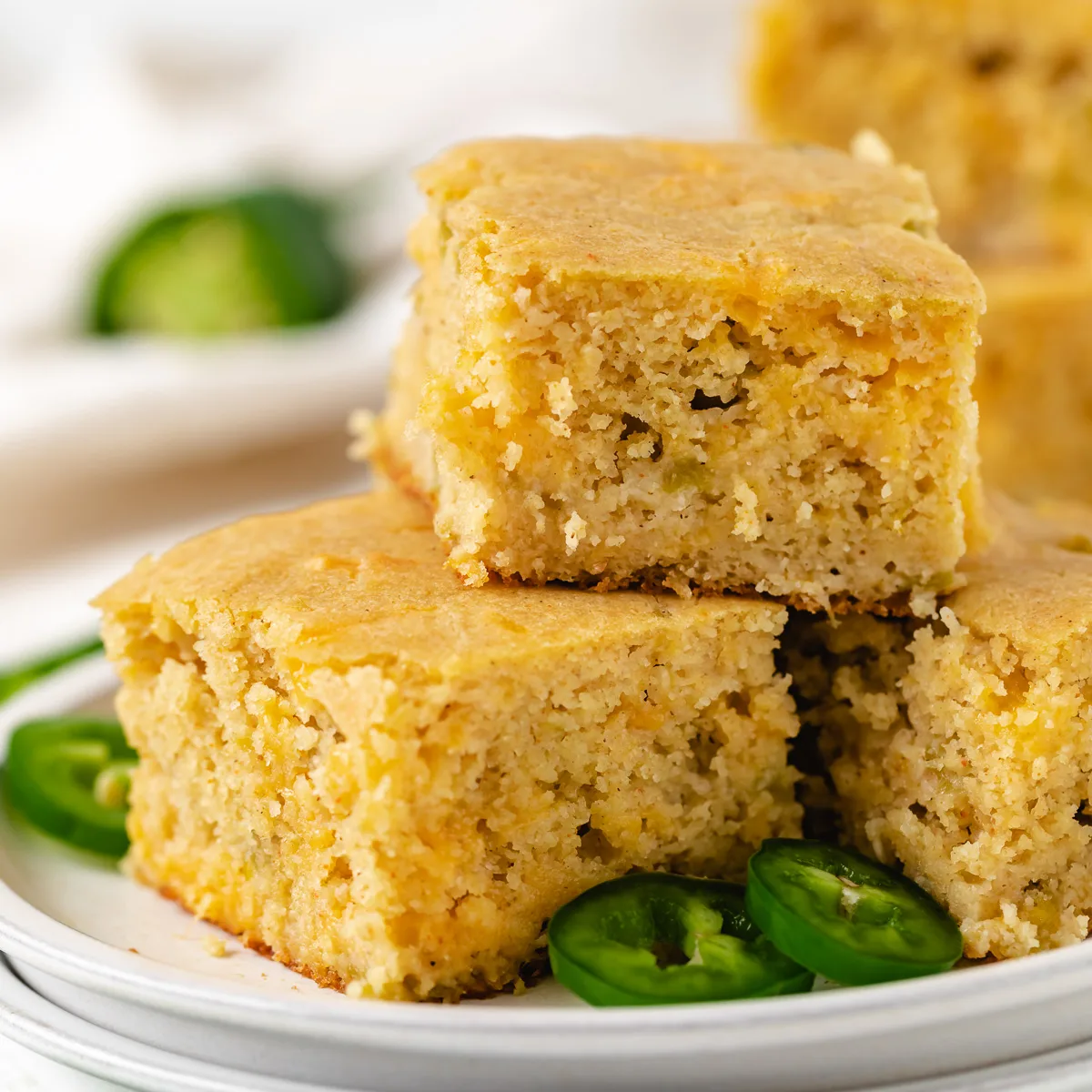 Plate stacked with cornbread and jalapeño slices.