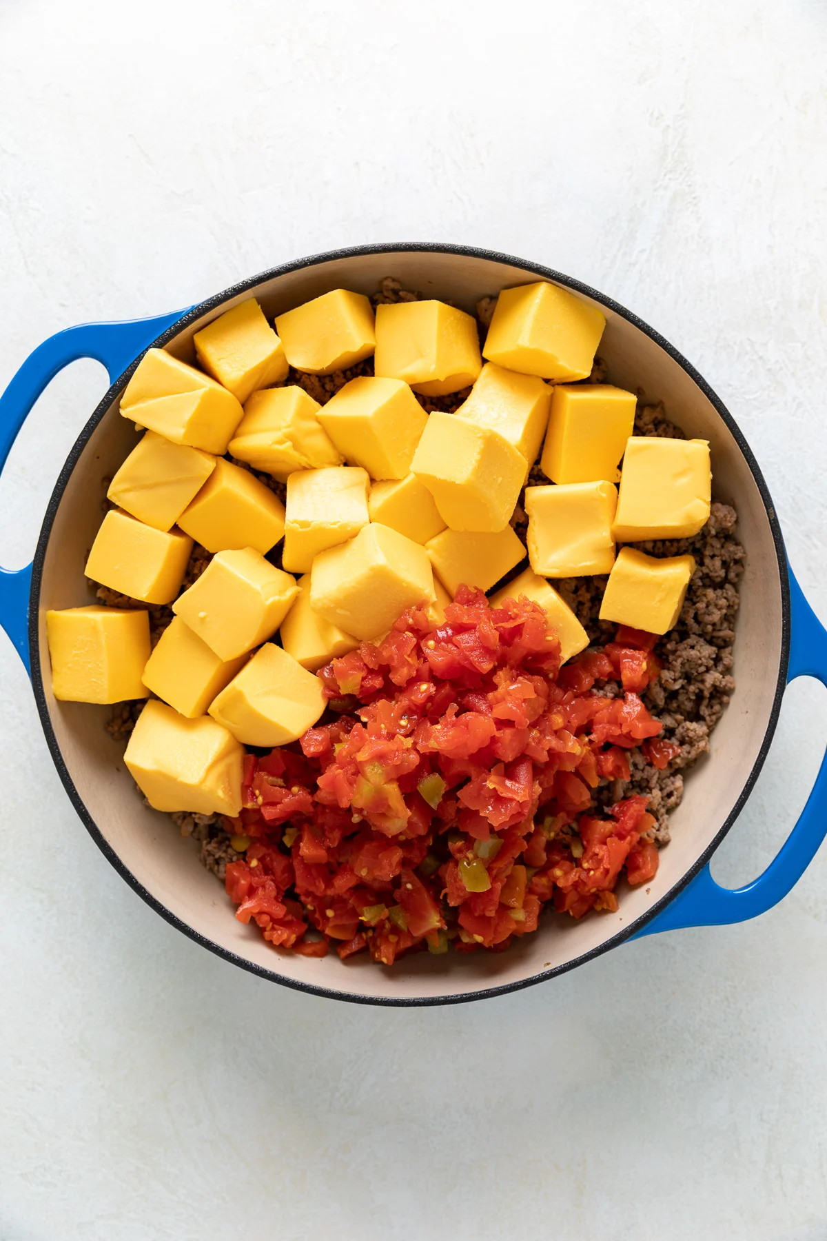 Browned meat, rotel and cubed velveeta in a pan.