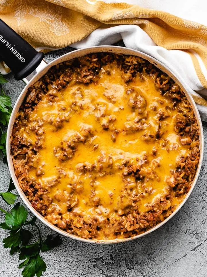 Close up view of beef and rice casserole topped with melted cheese.