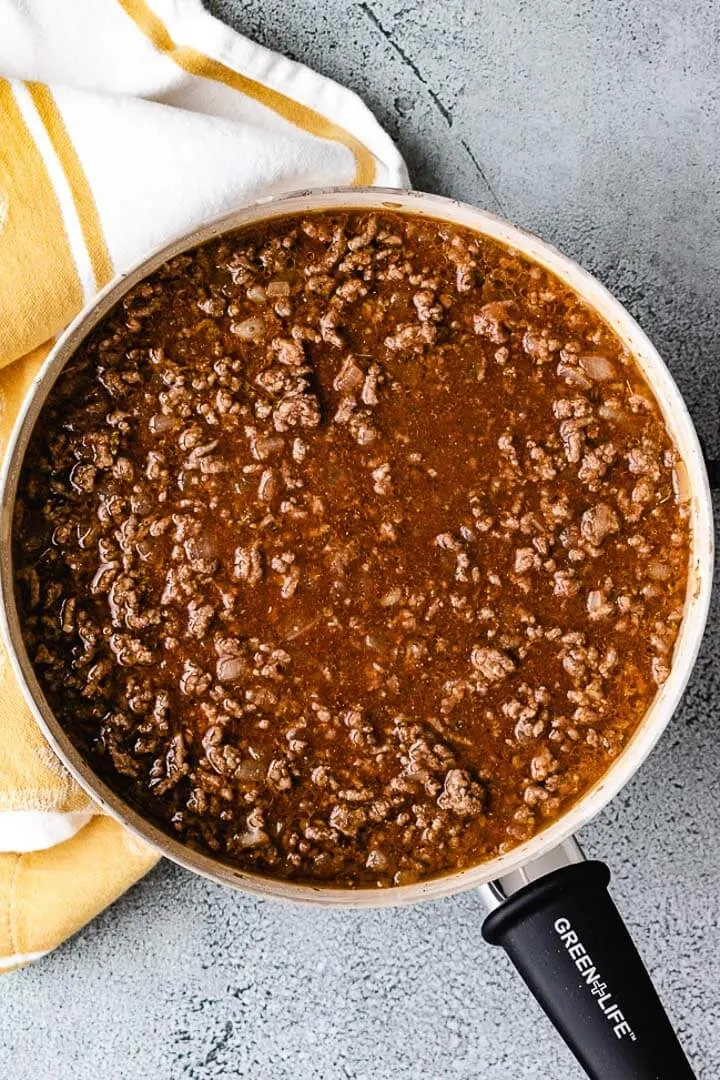 Top down view of ground beef with beef broth.