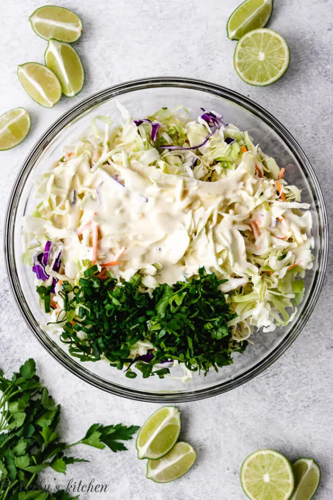 Slaw dressing poured over coleslaw mix.