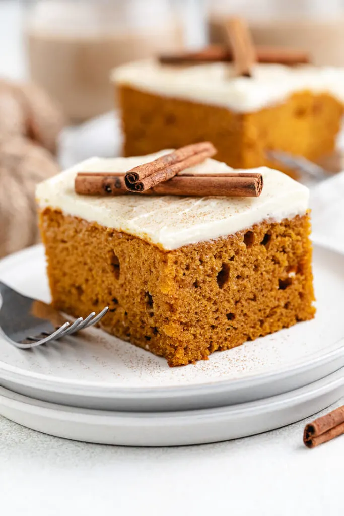 Cinnamon sticks laid over a slice of cake.