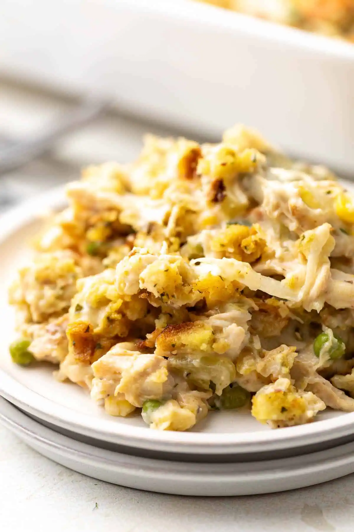 Scoop of chicken casserole on a stack of plates.