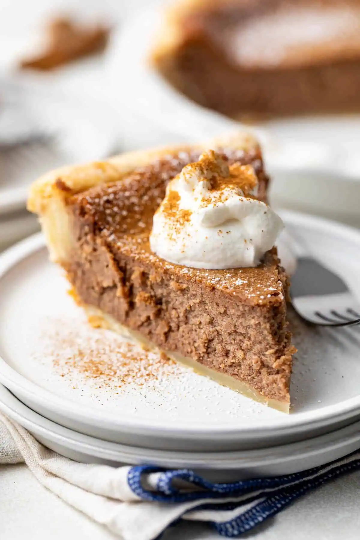 Whipped cream on top of a slice of pie.