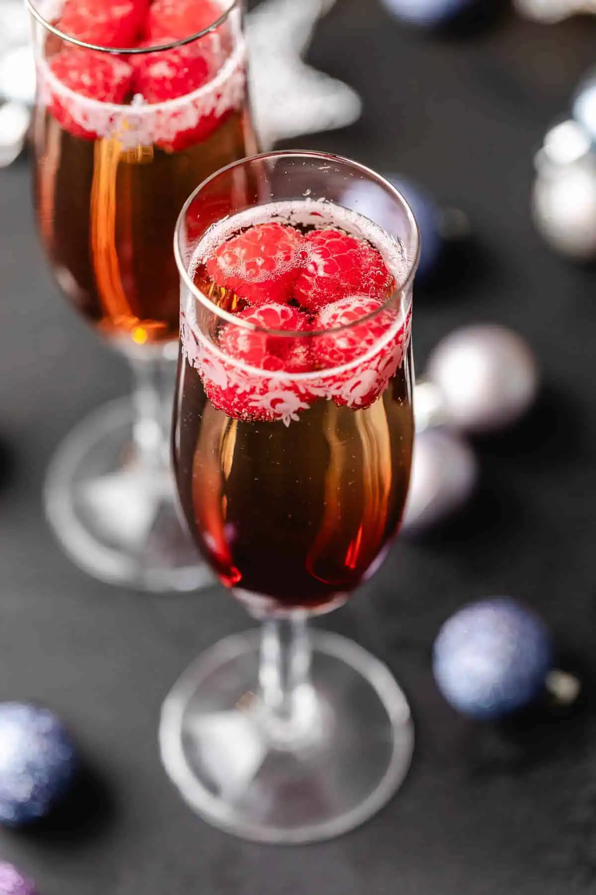 Top down view of raspberries floating in a glass of chambord and champagne.