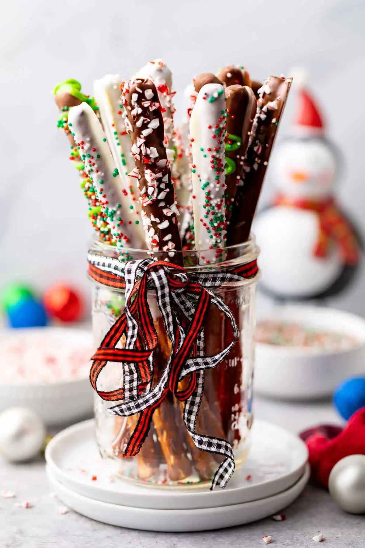 Side view of a mason jar holding chocolate pretzels.