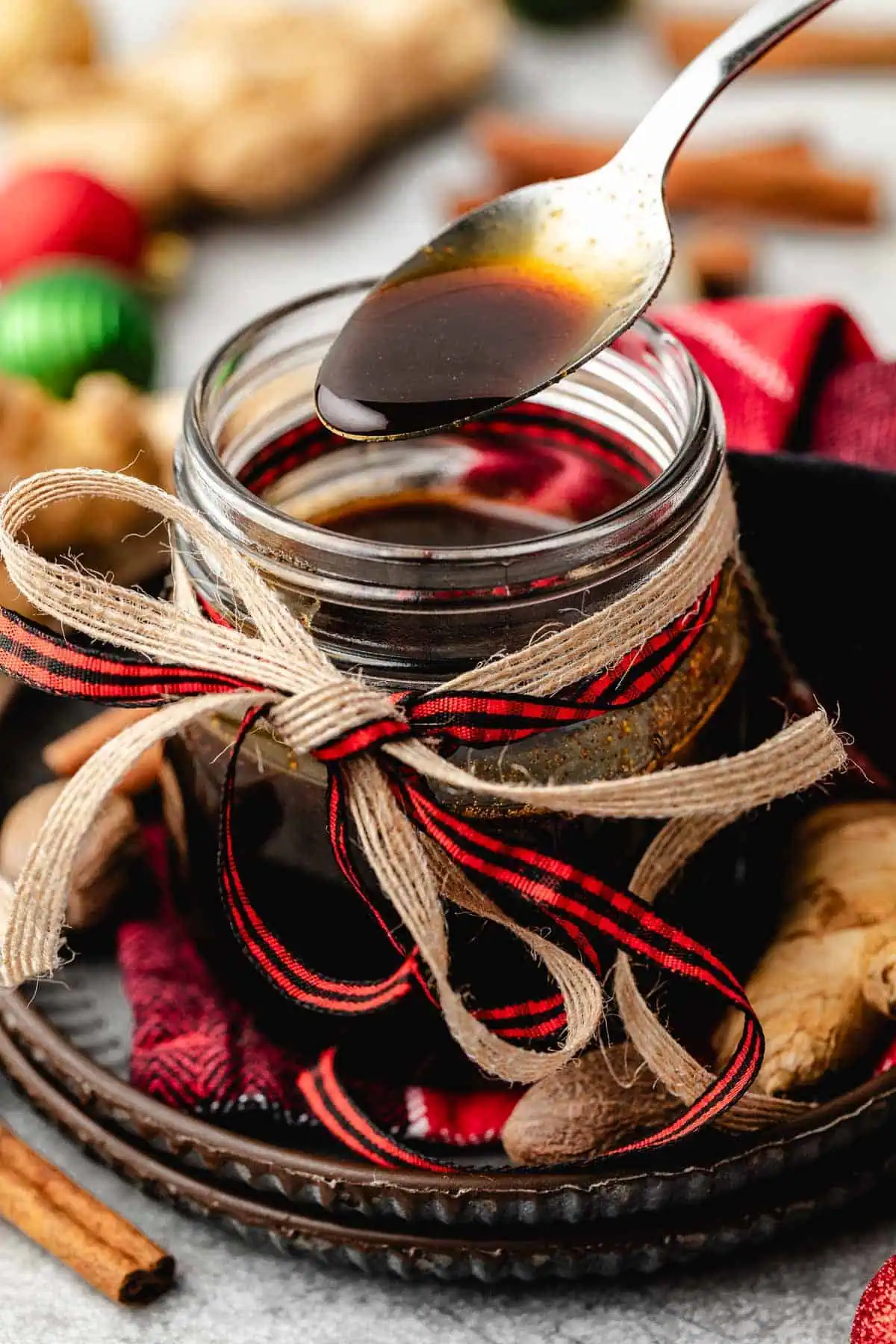 Spoon dipping into a jar of gingerbread simple syrup.