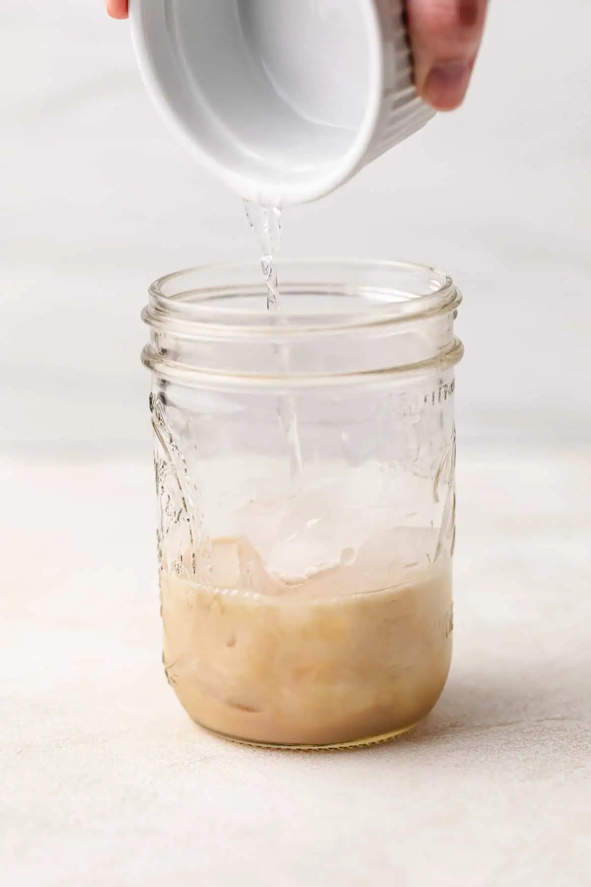 Butterscotch schnapps being poured into a jar.