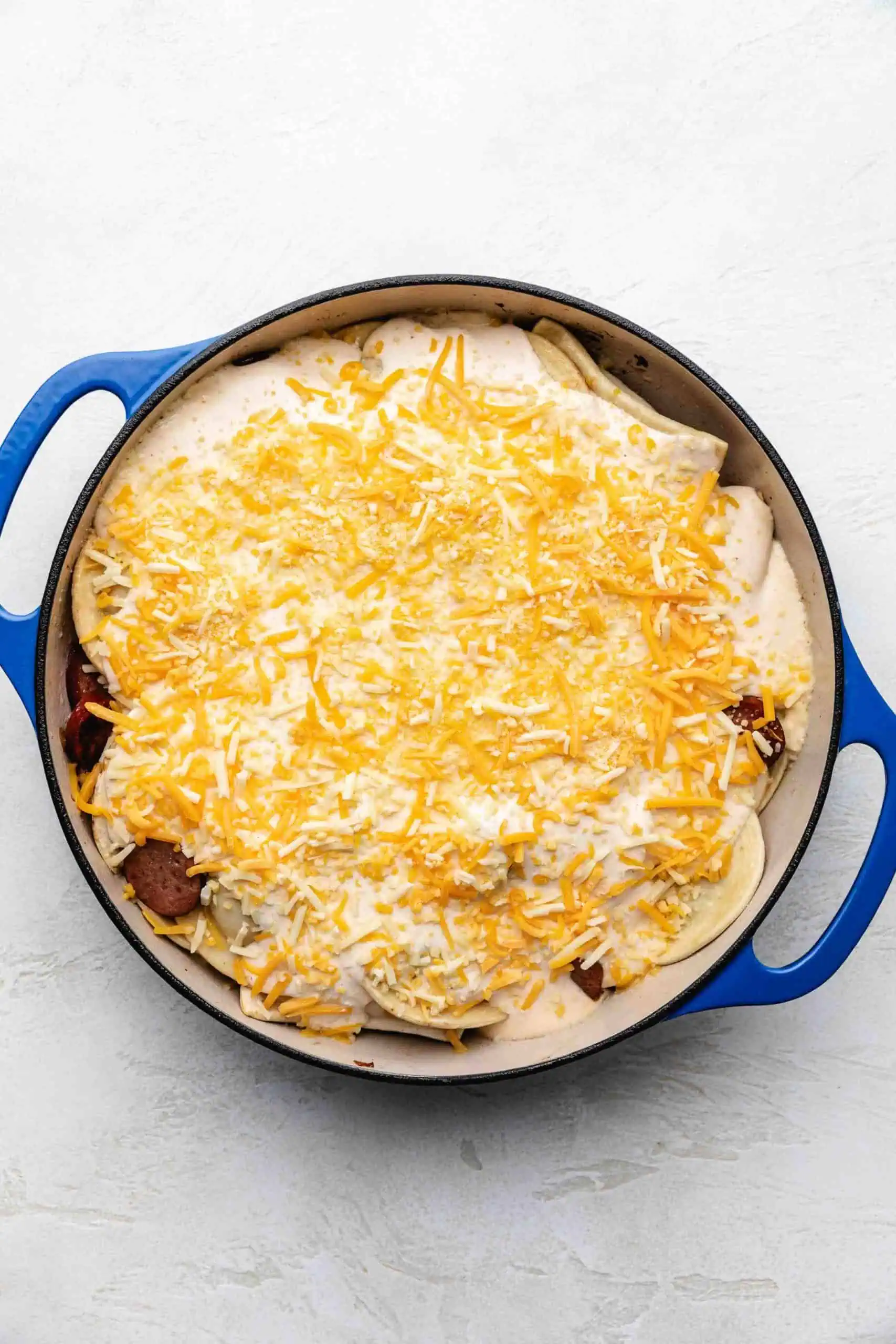 Cheese sprinkled over pierogi casserole.