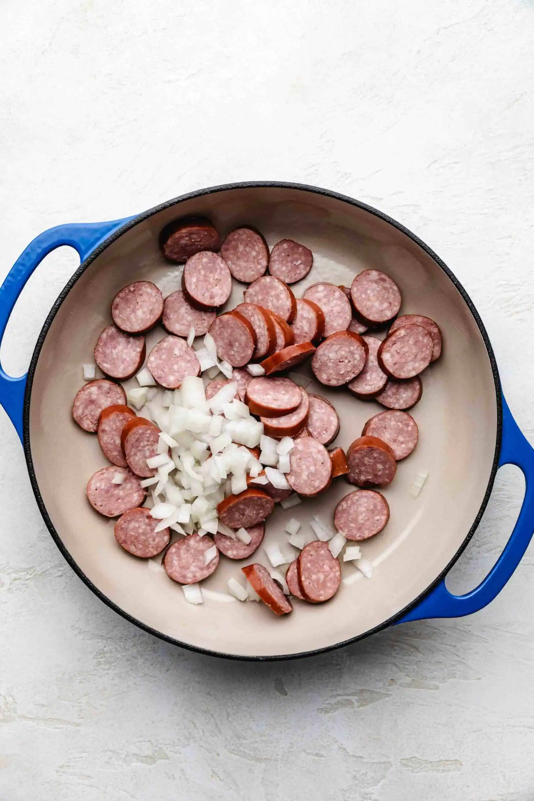 Sausage and onions in a pan.