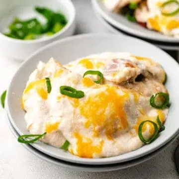 Close up view of cheesy pierogi and sausage casserole on a plate.