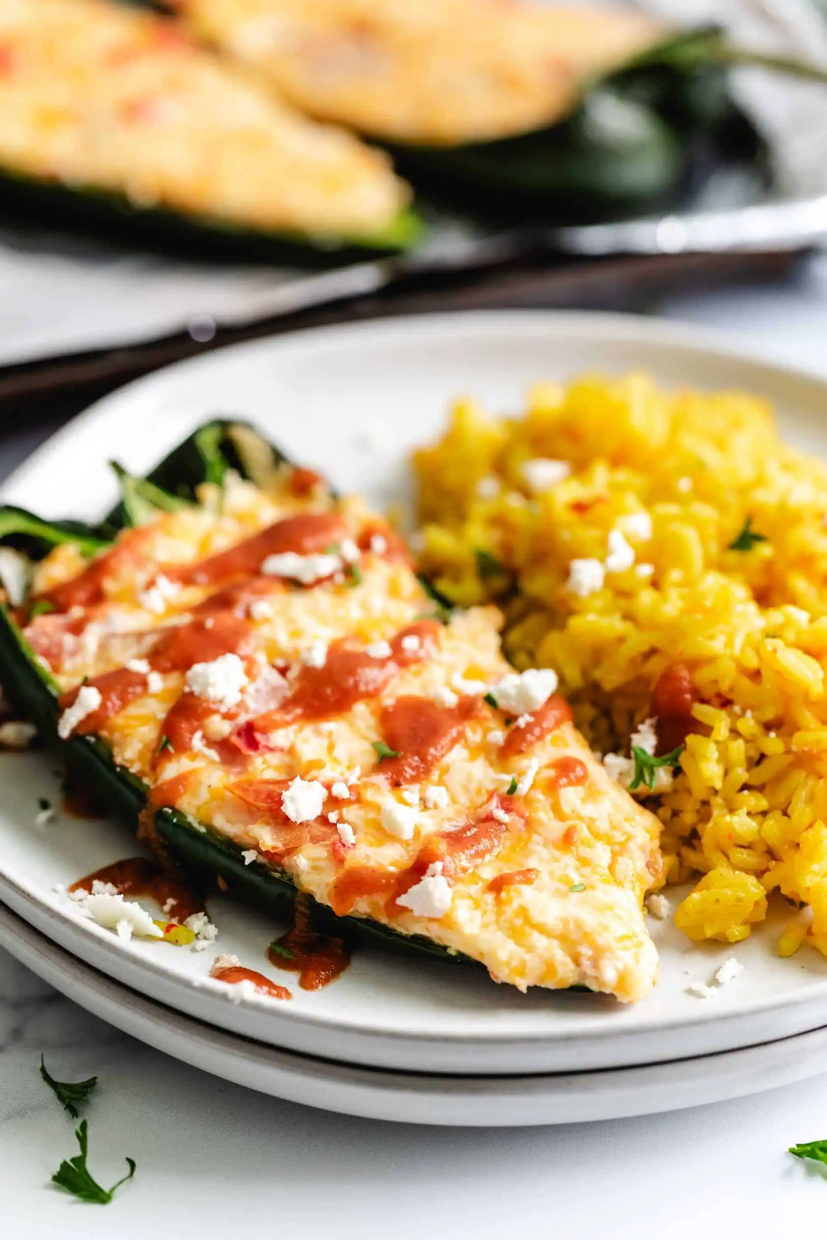 Stuffed poblano pepper on a white plate.