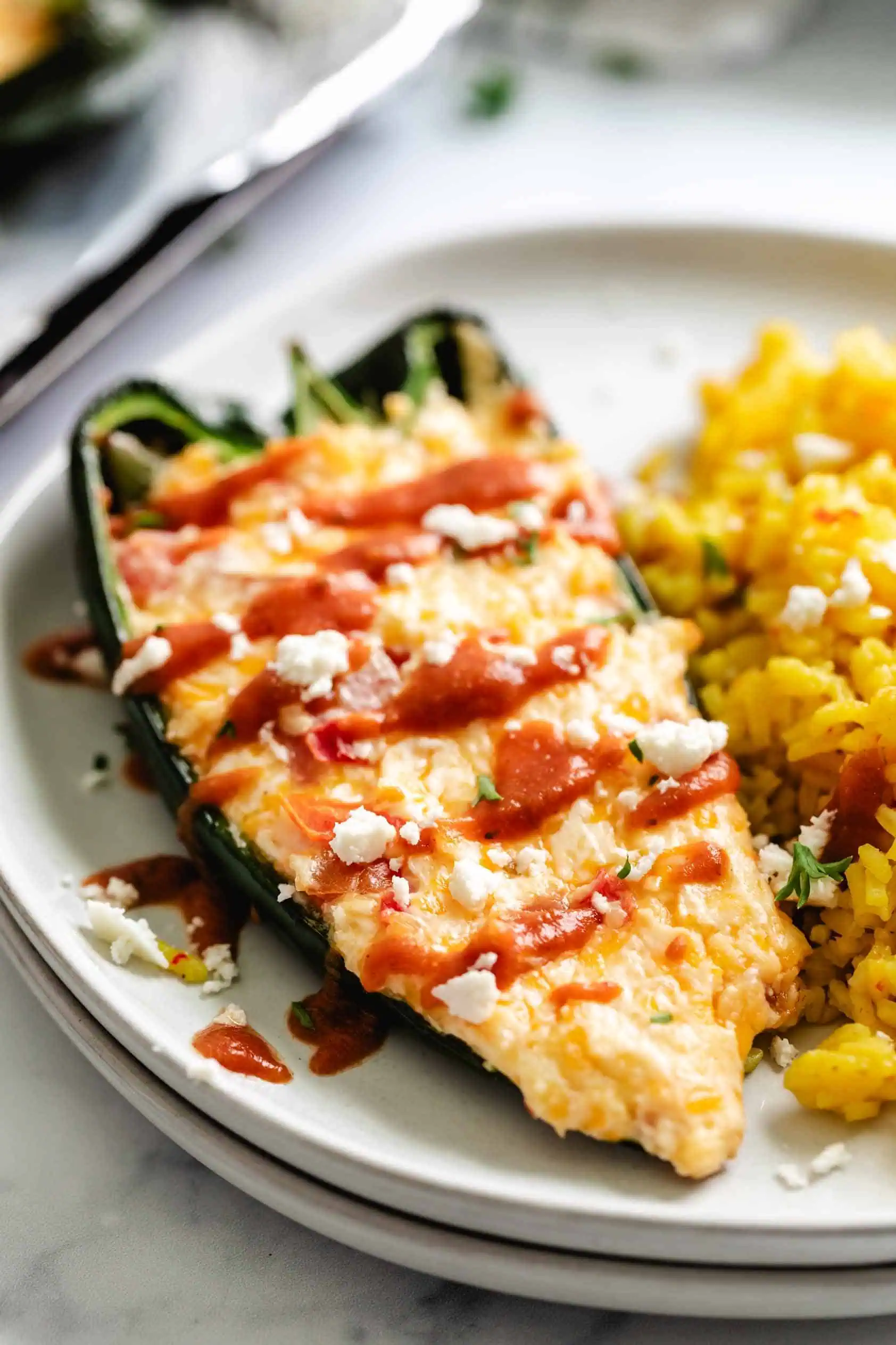 Cheese stuffed poblano peppers next to rice.