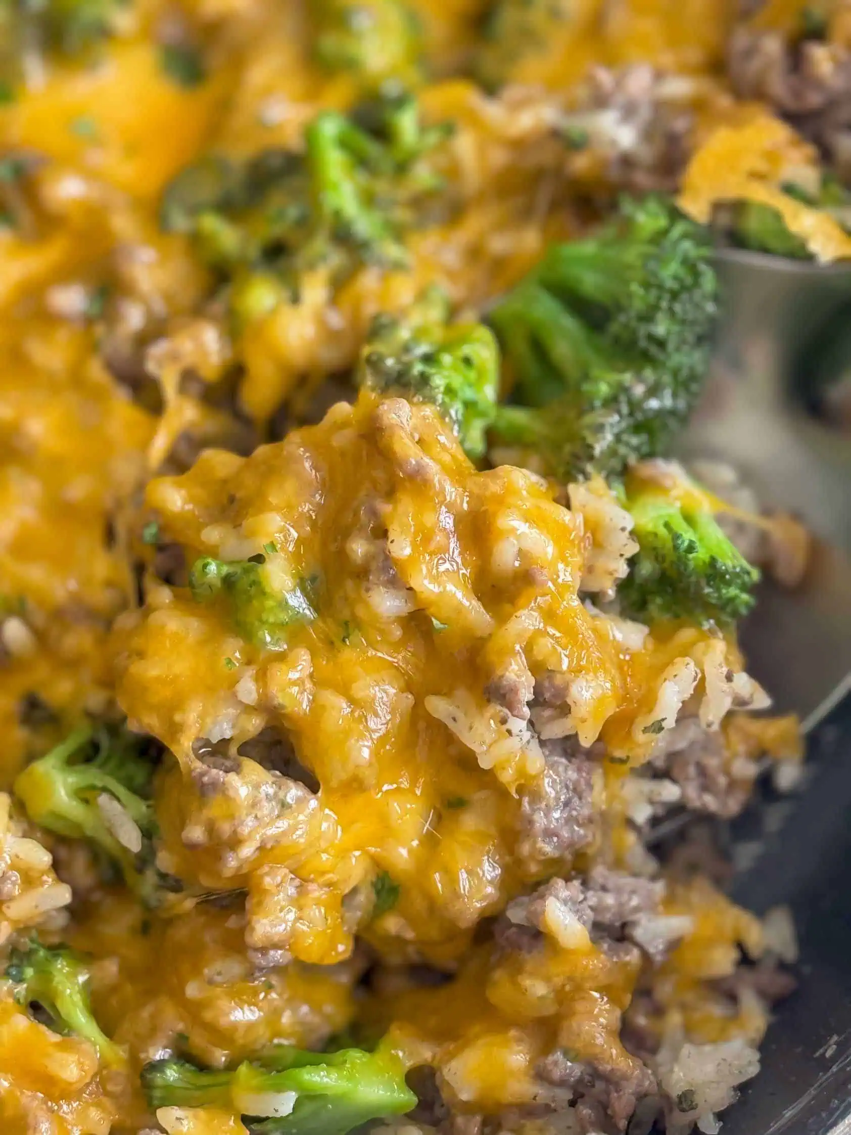 Close up view of beef and rice casserole on a spoon.