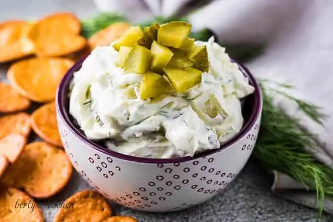 Dill pickle dip in a purple bowl.