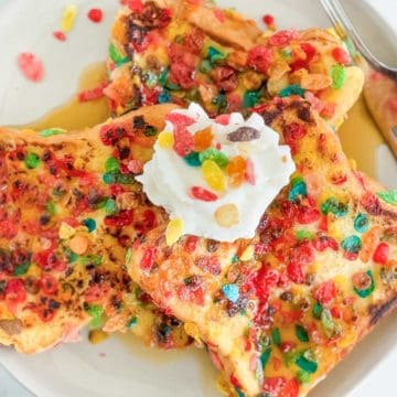 Fruity pebbles french toast topped with whipped cream.
