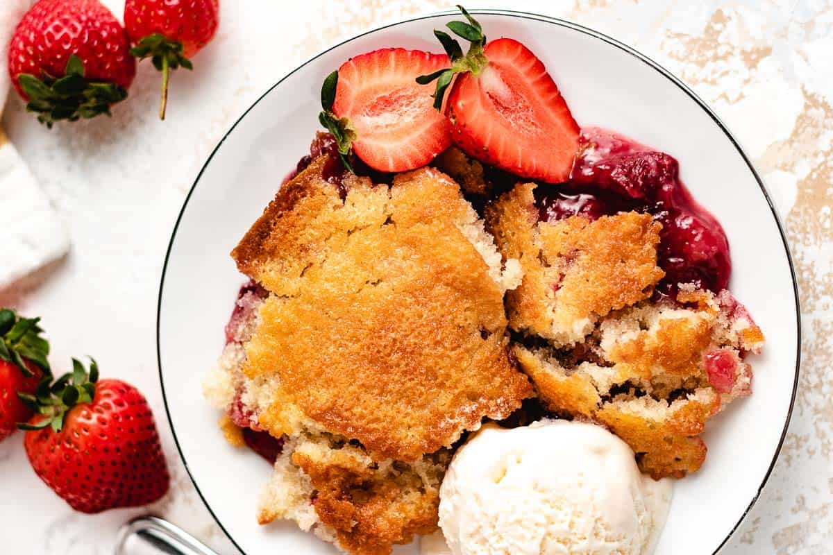 Top down view of strawberry cobbler with ice cream.