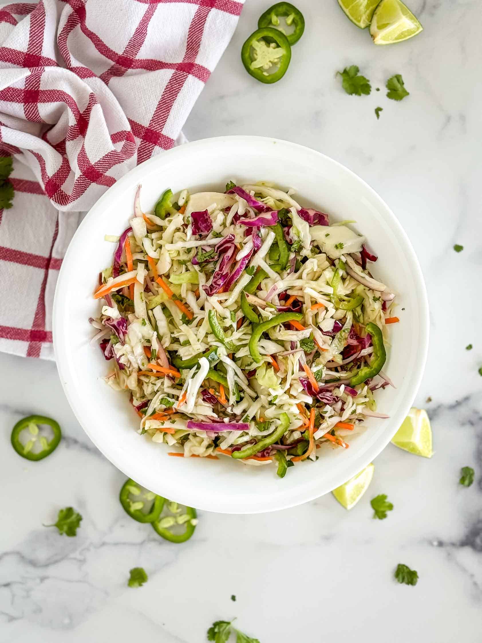 Coleslaw with jalapenos in a white bowl.