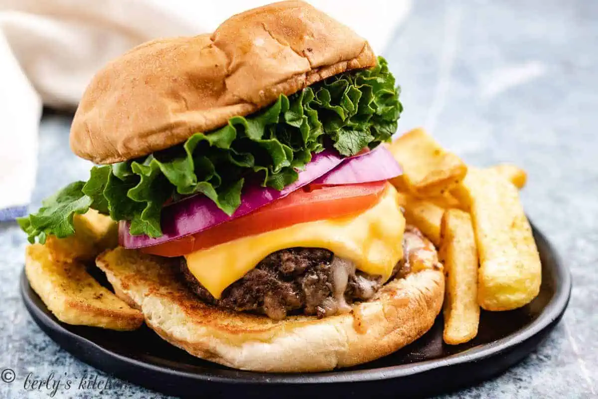 Stuffed burger topped with lettuce, tomato and cheese.