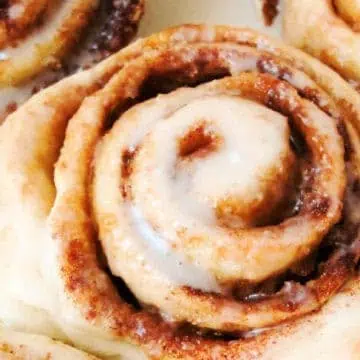 Close-up view of a freshly baked pastry with a swirl pattern, topped with a light layer of icing.