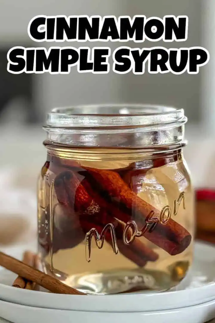 A mason jar filled with cinnamon syrup and cinnamon sticks inside, with the text "cinnamon simple syrup" in bold black font at the top.