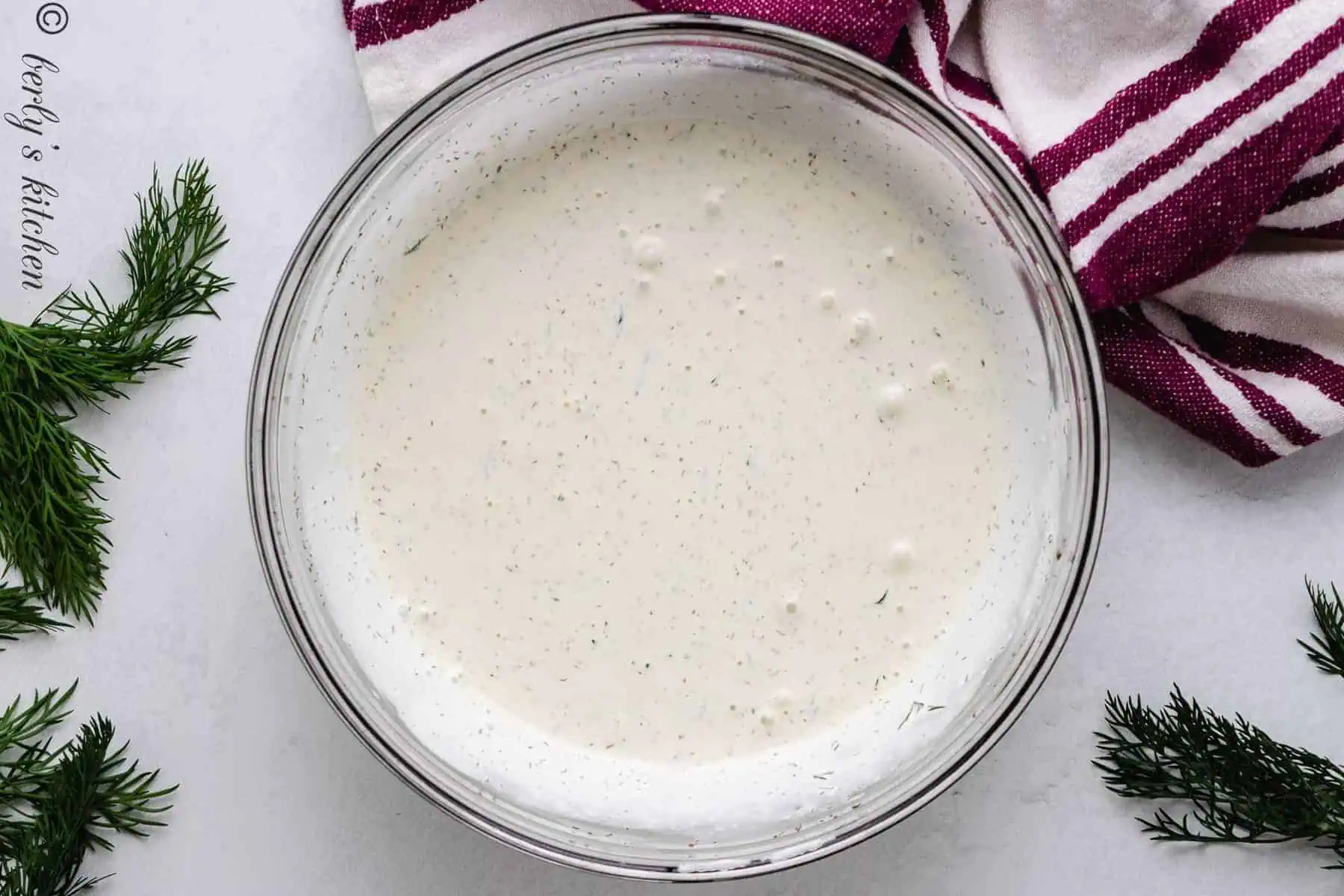 Top down view of dill dressing in a large bowl.