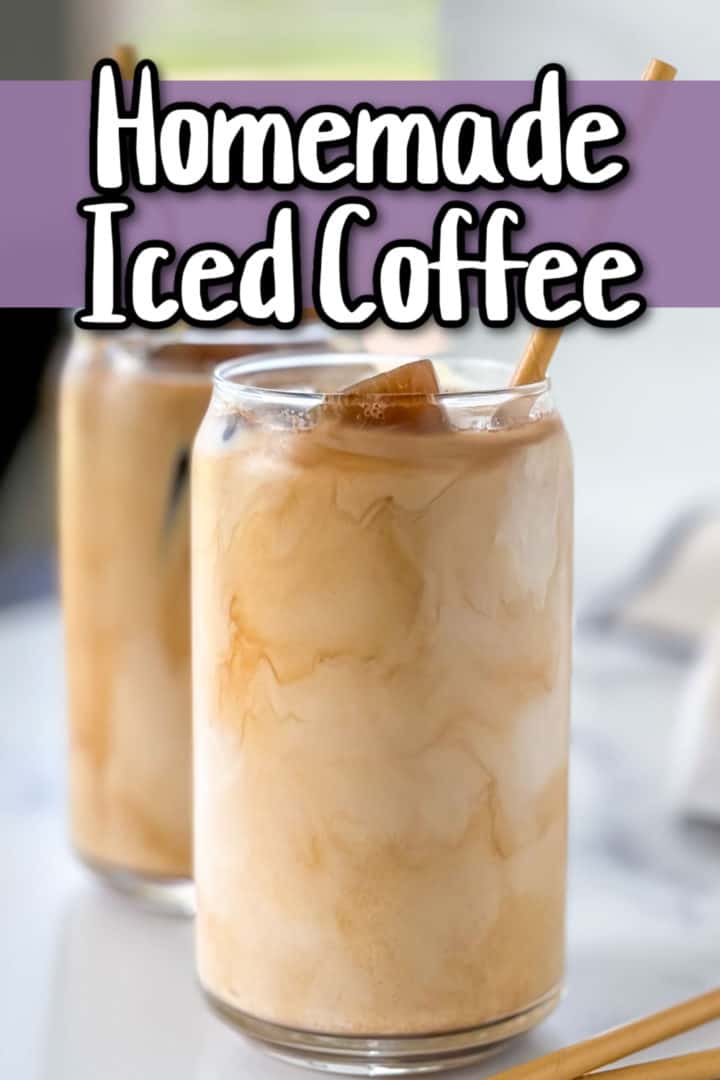 A glass of homemade iced coffee with a bamboo straw, showcasing a creamy swirl effect.