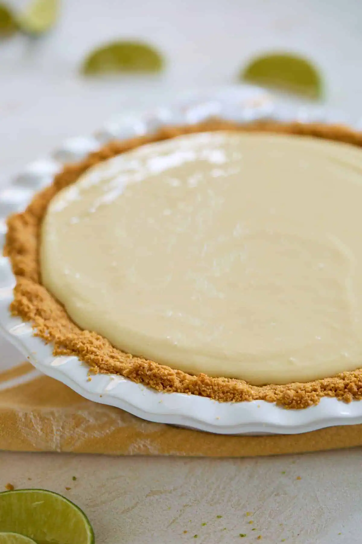 Unbaked key lime pie filling poured into the graham cracker crust, ready to be baked.