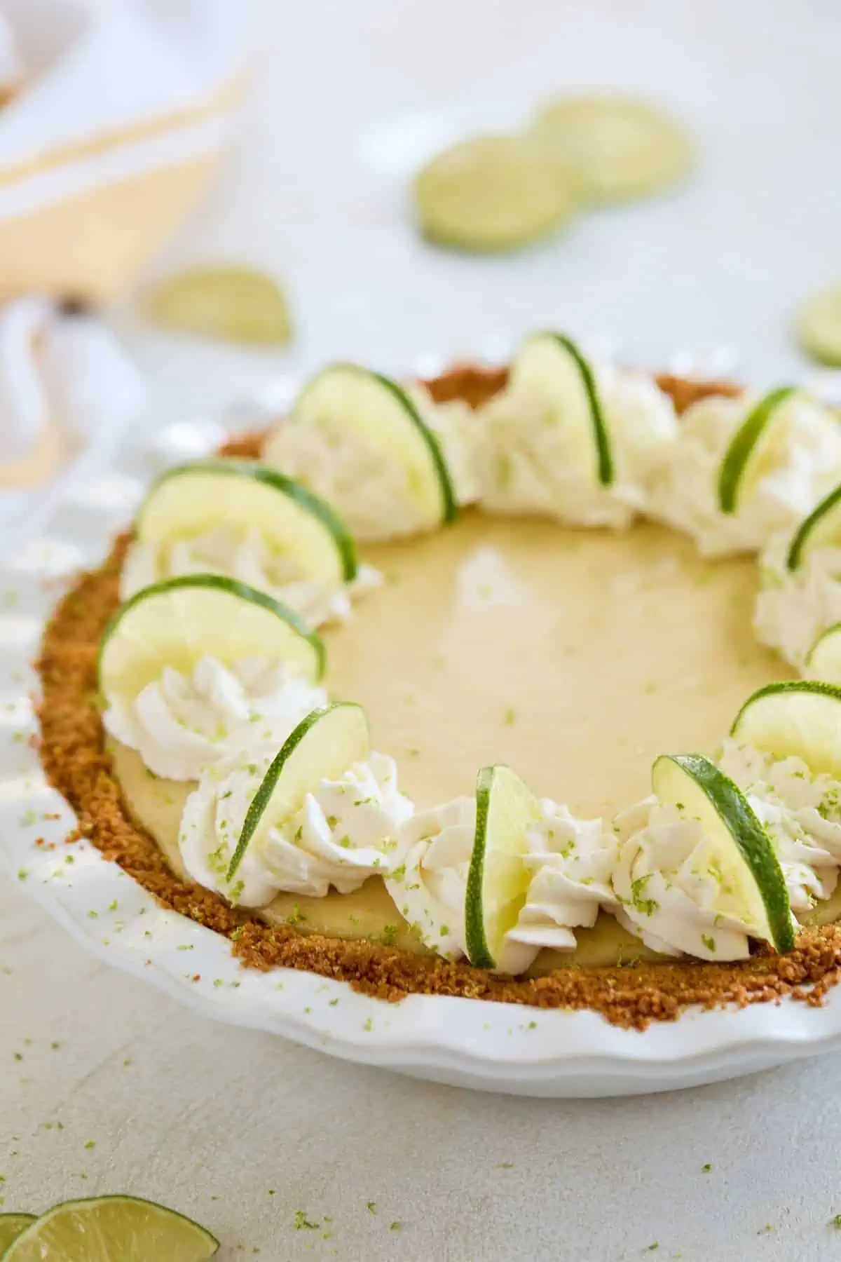 A decorated pie with whipped cream and lime slices, ready to be served.