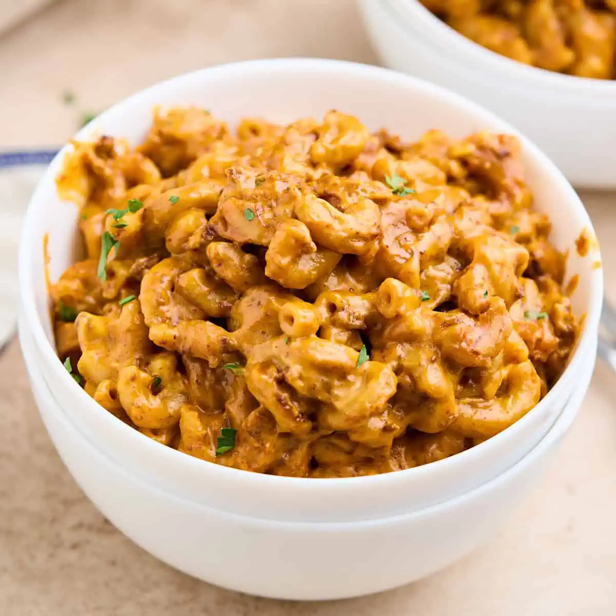 A delicious serving of chili mac and cheese in a white bowl.