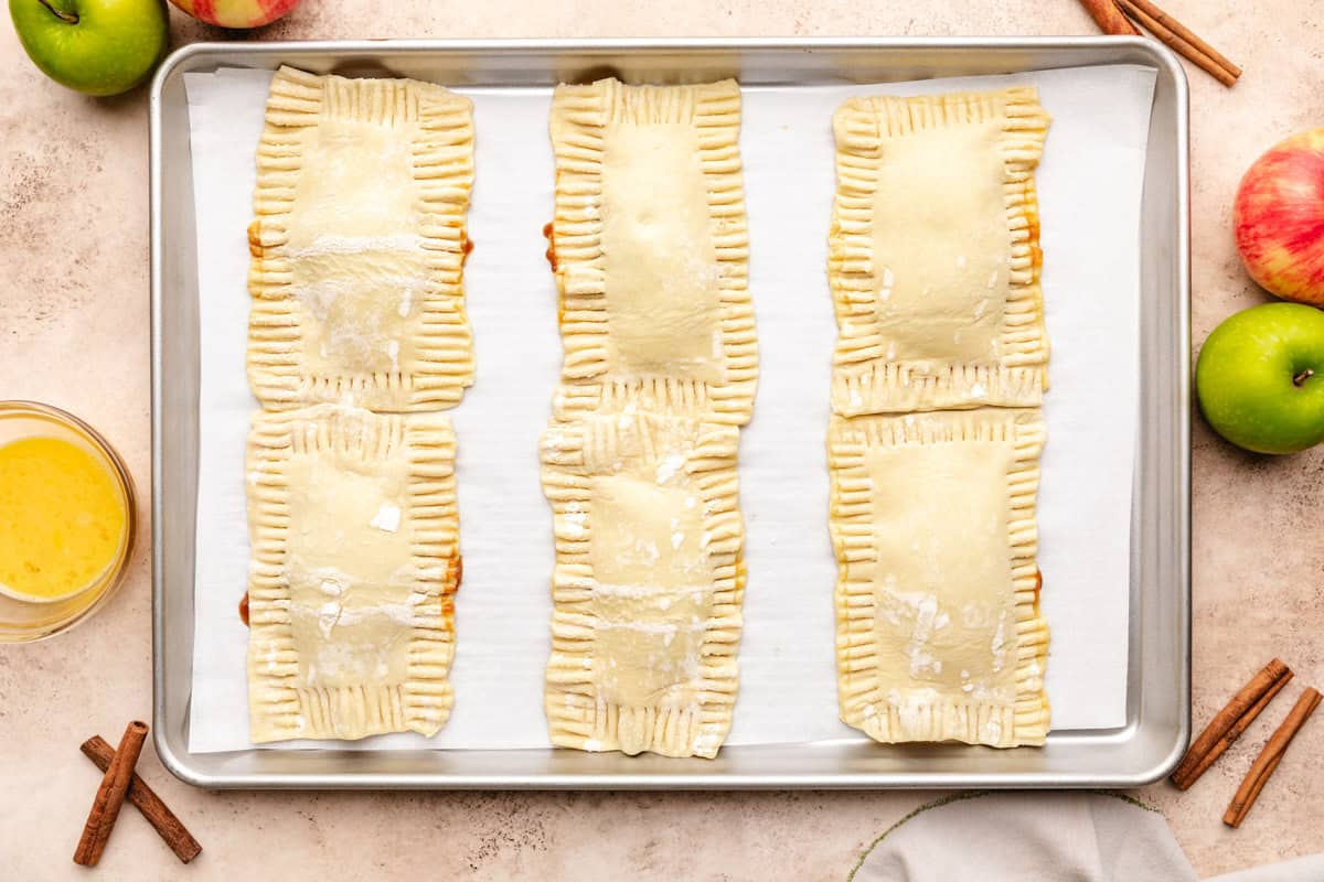 Unbaked hand pies crimped with a fork.