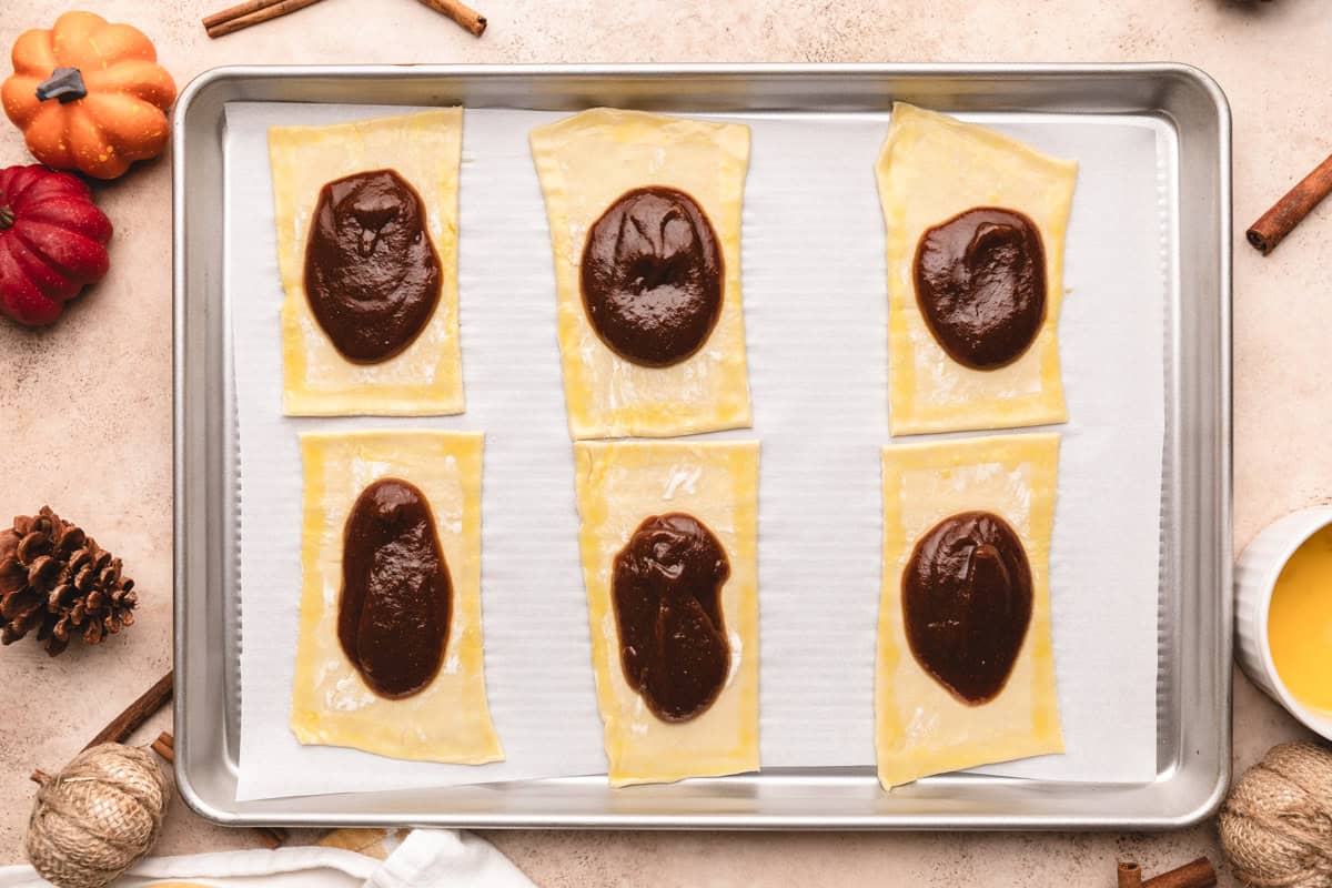 Puff pastry rectangles filled with pumpkin butter hand pie filling and egg wash around the edges.