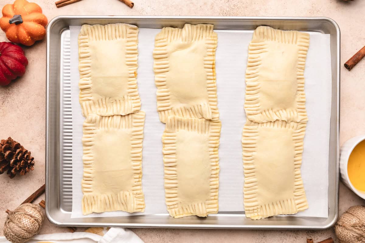 Crimped edges on puff pastry hand pies filled with pumpkin butter.