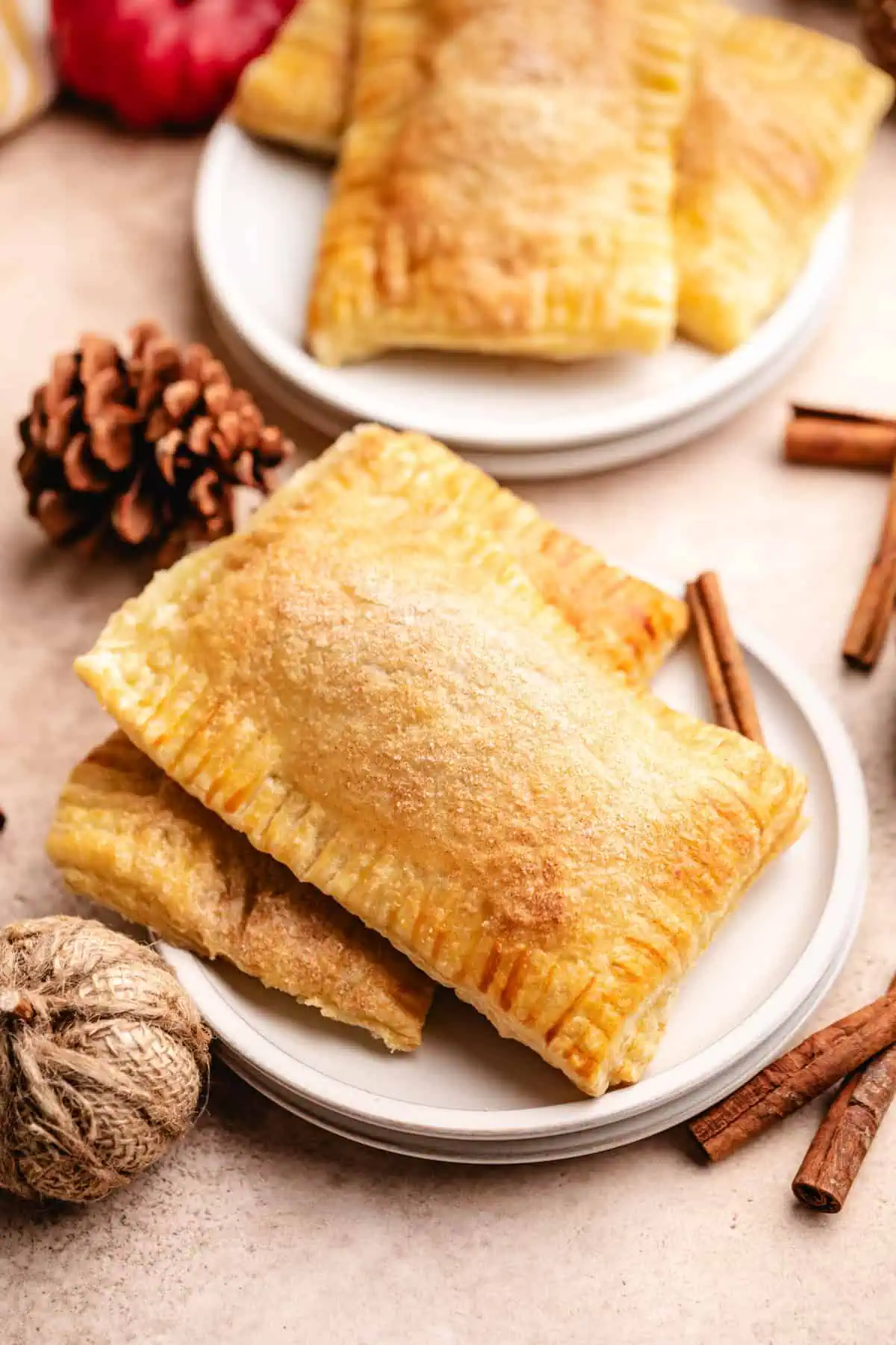 Golden pumpkin hand pies made with puff pastry and pumpkin butter, with flaky edges crimped to seal the sweet pumpkin filling.