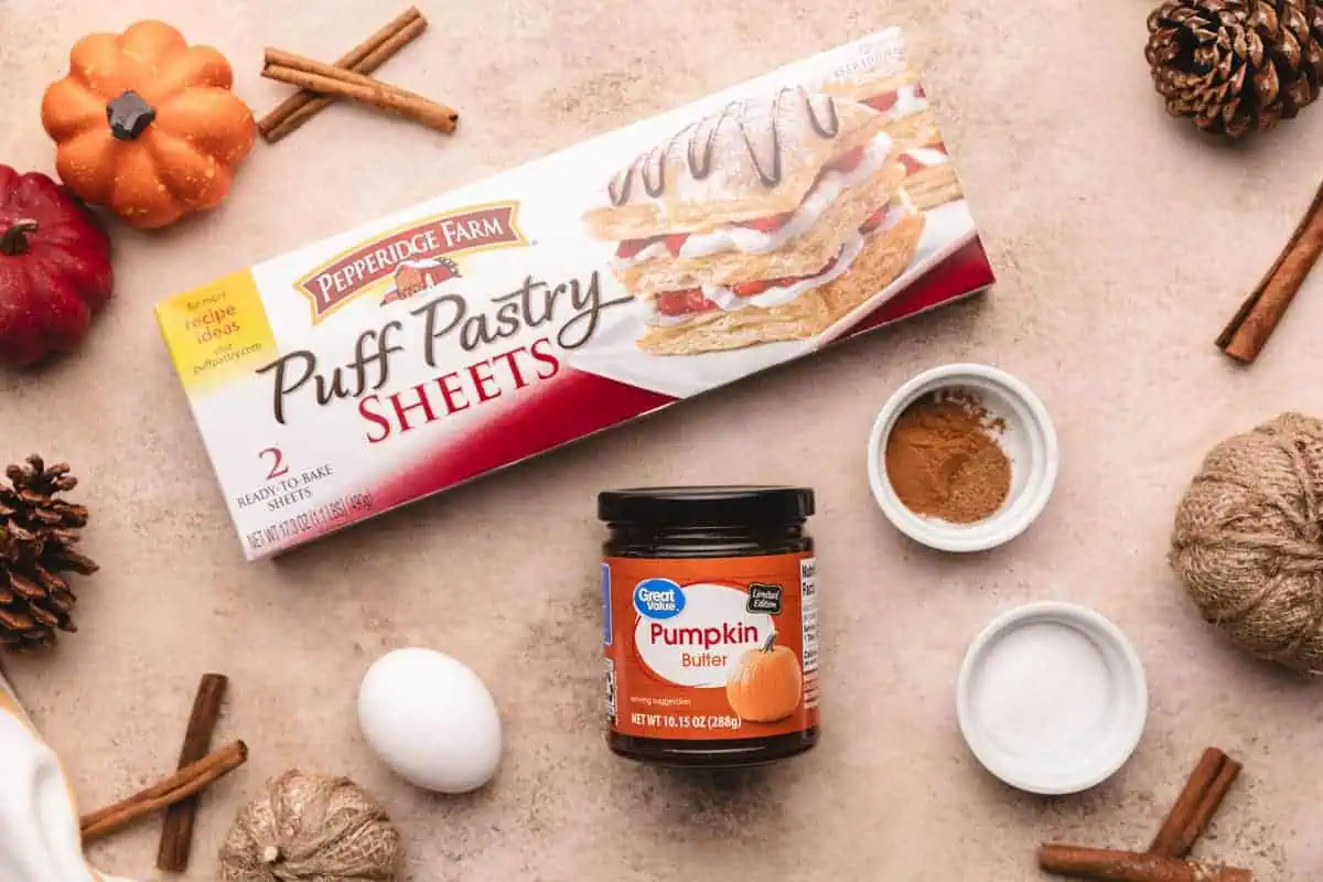 A delicious spread of ingredients for hand pumpkin pies featuring puff pastry sheets and pumpkin butter.