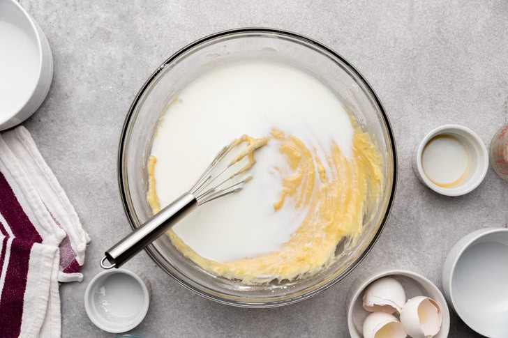 Milk poured into a bowl of cake batter.