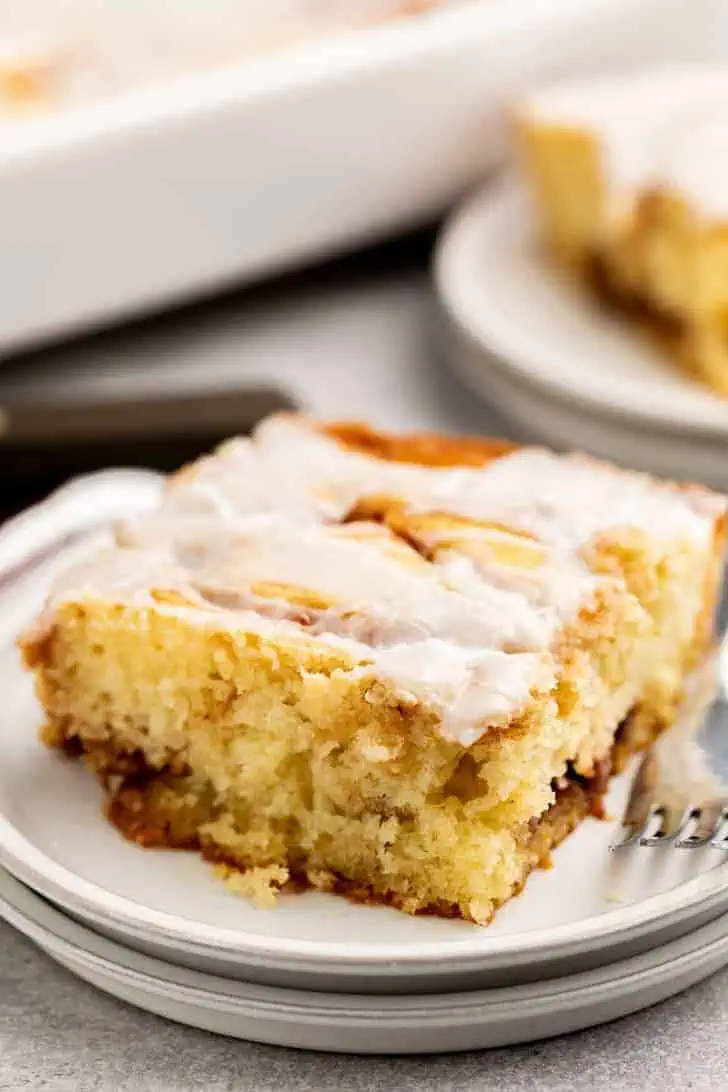 Close up view of cinnamon roll cake next to a fork.