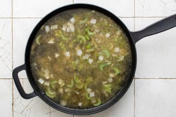 Broth added to a pan of celery and onions.