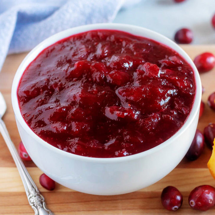 Close up view of cranberry sauce in a white bowl.