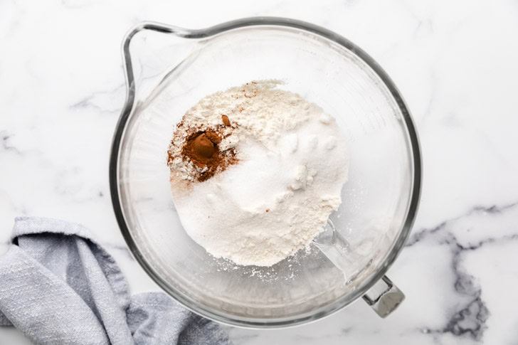 Flour, sugar, yeast, salt, and pumpkin pie spice in a bowl.