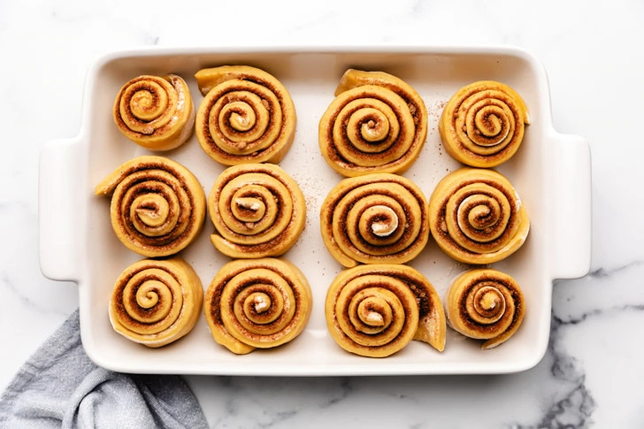 Unbaked cinnamon rolls in a pan.