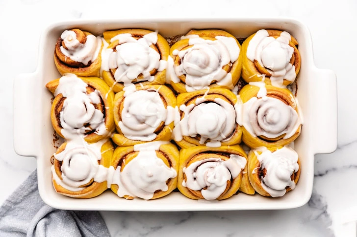 Overhead view of a pan of freshly baked pumpkin cinnamon rolls.