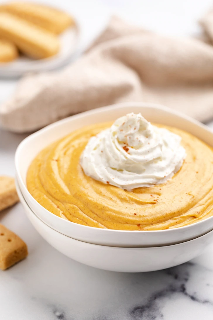 Whipped cream over pumpkin cheesecake dip.