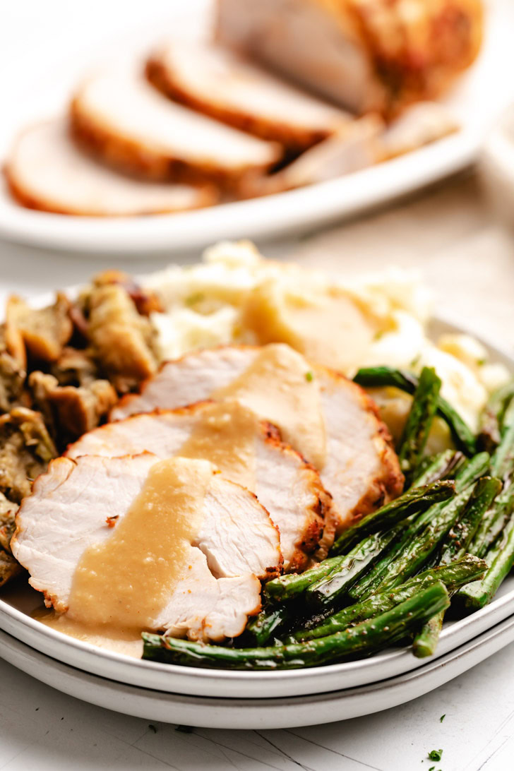 Plate filled with turkey breast and sides.