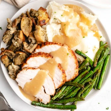 Close up view of gravy drizzled over turkey breast.