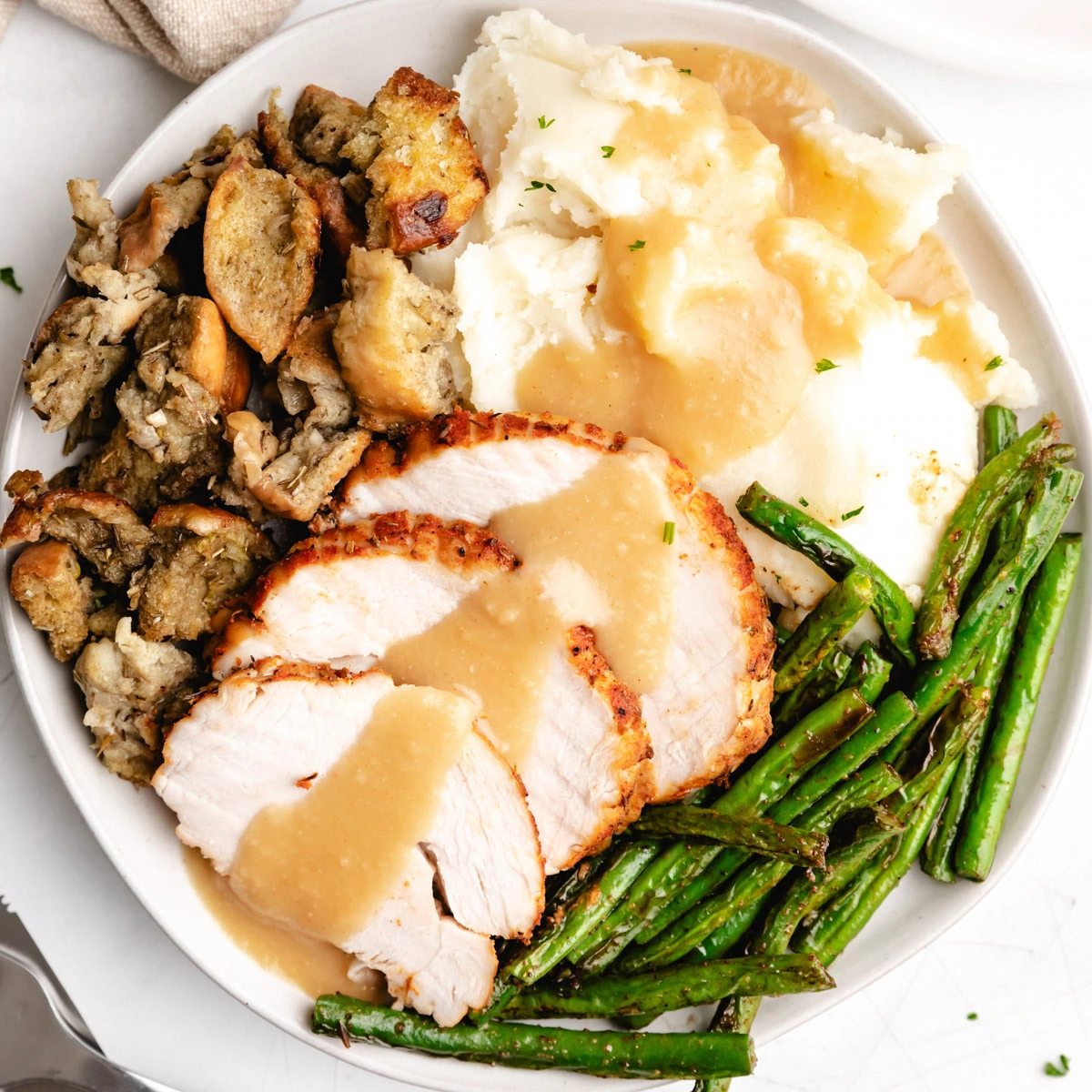 Close up view of gravy drizzled over turkey breast.